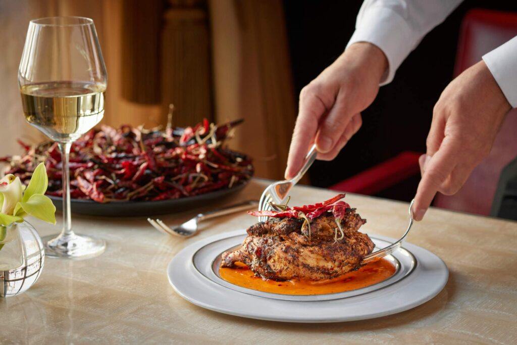 Chicken served on a plate with red chilli on it